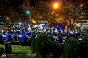 L'autunno all'aperto e i lunghi tavoli condivisi rendono la notte gioviale (foto di bassonista Steven Louie)