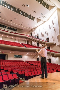 Il trombonista Alistair Crawford si riscalda prima che la sala da concerto si riempia