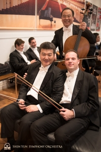 Il primo bassista Juraj Kukan (a destra) e il bassista Wei Liu aspettano di riunirsi con i loro strumenti sul palco mentre il violoncellista James Zheng non ha bisogno di aspettare!
