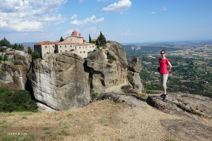 A circa 8.000 Km di distanza a Meteora, in Grecia, la ballerina Daniella Wollensak posa con il monastero di Santo Stefano alle sue spalle; l'edificio, attualmente un convento di suore, è accessibile da un piccolo ponte e la sua posizione in cima alla montagna lo fa sembrare sospeso a mezz'aria
