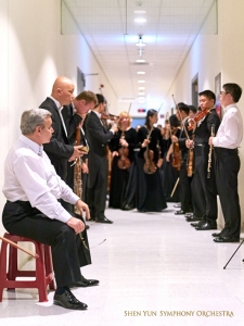 Dietro le quinte, i membri dell’orchestra sono quasi pronti per entrare nella sala da concerto