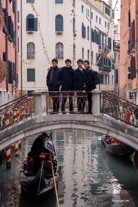 I ballerini si fermano su uno degli oltre 400 ponti che collegano Venezia, mentre una gondola vi passa sotto. (Foto di William Li)

